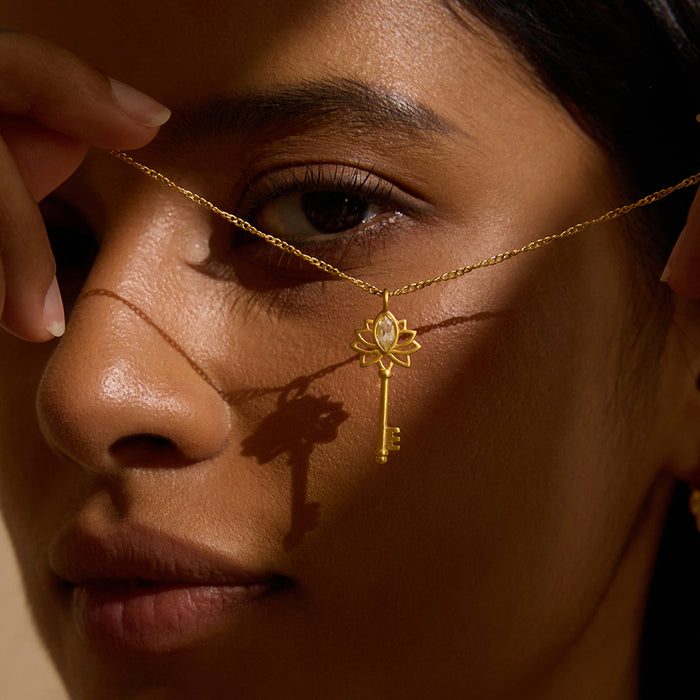 Close-up of a woman wearing the Key to My Heart White Topaz Key Necklace, featuring a delicate gold key design adorned with a lotus and white topaz, symbolizing love and abundance in spiritual jewelry. Perfect for meditation, this talisman enhances manifestation, making it meaningful for yoga, zodiac affinity, and personal protection.