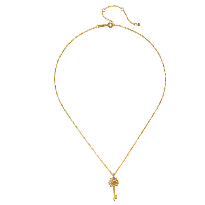 The Key to My Heart White Topaz Key Necklace displayed elegantly, showcasing its gold-plated finish and lotus detail, a perfect piece of spiritual jewelry. This necklace represents empowerment and the transformative power of love, making it an ideal talisman for meditation and supporting manifestation in one's life.