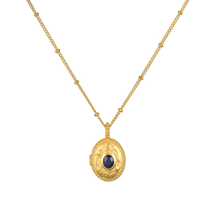 Lotus Sapphire Birthstone Locket Necklace - September displayed on a white background, featuring an 18kt gold plated locket adorned with a sparkling sapphire. This spiritual jewelry serves as a meaningful talisman, perfect for meditation and manifestation. Ideal for those seeking charm and protection in their yoga practice.