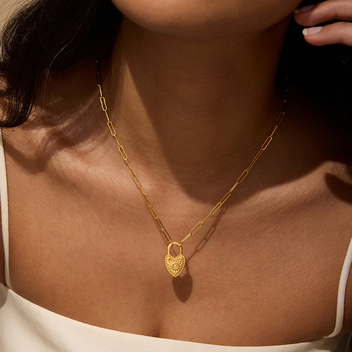 Model wearing the Love Everlasting Padlock Heart Necklace layered with a simple gold chain, showcasing its elegant design as a piece of spiritual jewelry that symbolizes protection and intention in meditation.