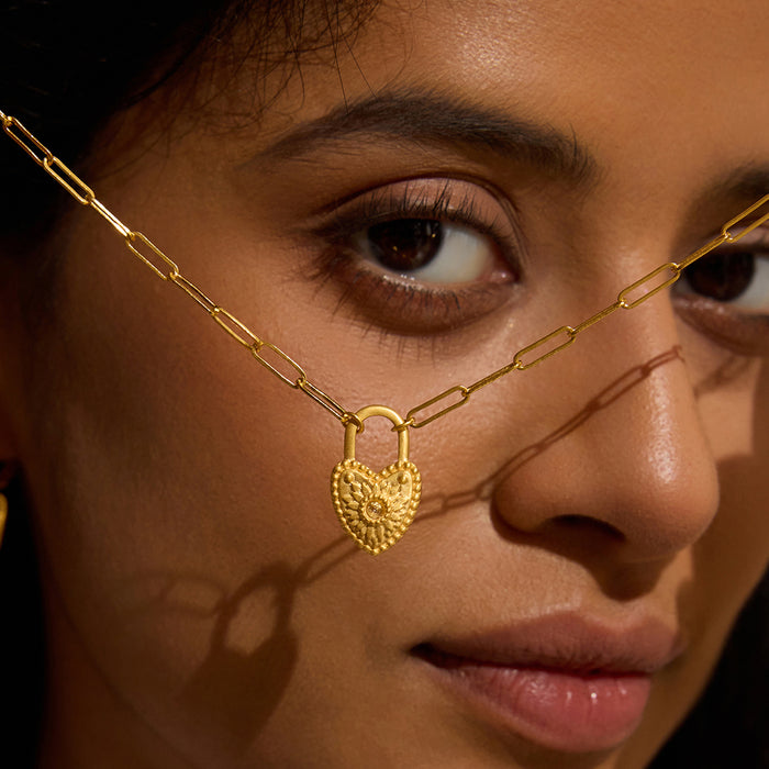 Portrait of a woman with the Love Everlasting Padlock Heart Necklace around her neck, highlighting the intricate heart pendant. This piece serves as a meaningful talisman representing love, suitable for yoga and spiritual practices.