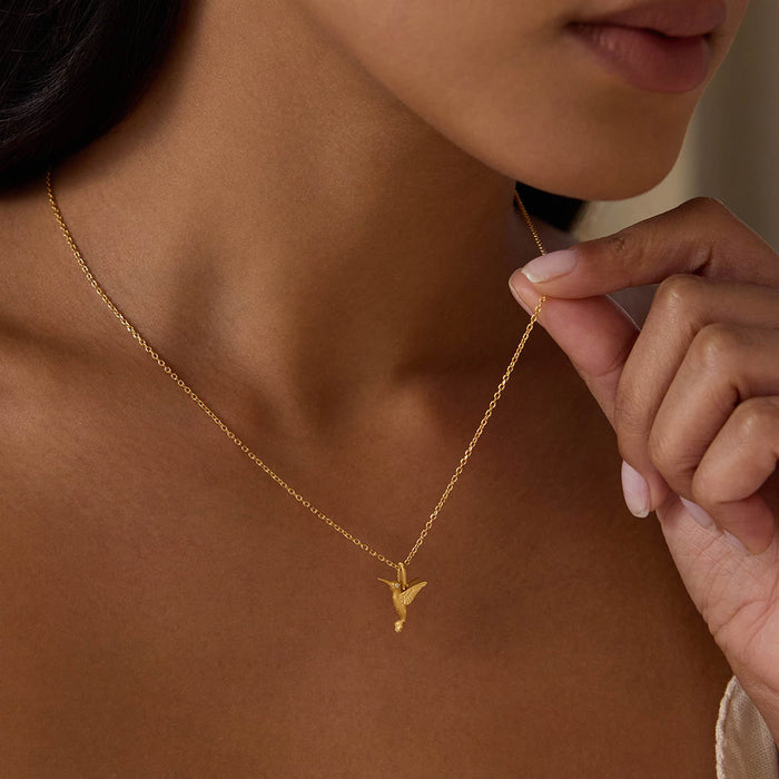 A close-up of the Loving Devotion Hummingbird Necklace being held by a model, highlighting its beautiful design and the meaningful presence it brings as a talisman for protection and spiritual connection.