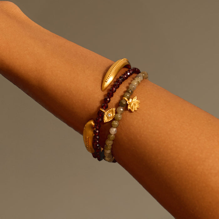 Display of the Loving Protection Garnet Evil Eye Bracelet among other beautiful bracelets, combining spiritual elements with stunning design. A perfect accessory for yoga lovers, the bracelet embodies protection and serves as a meaningful talisman for manifestation and spiritual growth.