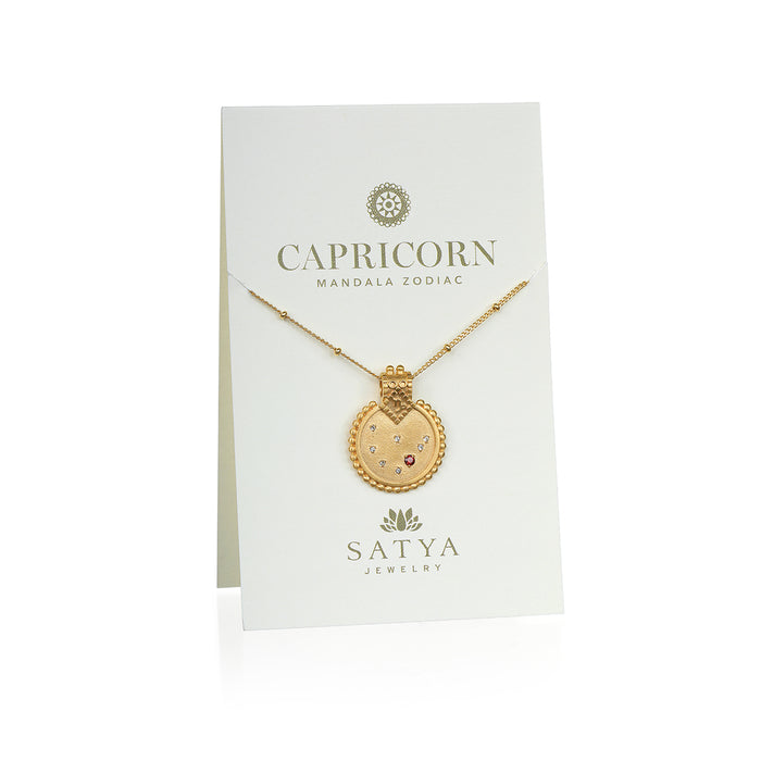 Mandala Zodiac Capricorn Red Garnet Necklace displayed on a beautiful presentation card by Satya Jewelry. This sacred amulet combines the essence of Capricorn with a touch of hamsa symbolism, ideal for spiritual jewelry and meditation gifts.