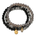 Manifest Fortune Gemstone Bracelet Set featuring a trio of healing gemstones including grey agate, black onyx, and black rutilated quartz. This spiritual jewelry is perfect for meditation and serves as a talisman for protection and manifestation, ideal for those who practice yoga and seek meaningful connections with their zodiac.