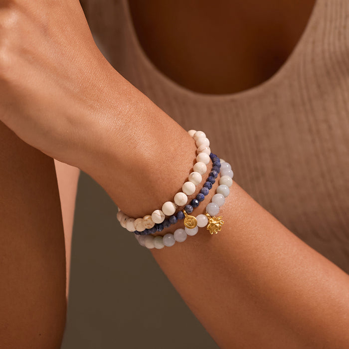 A close-up of the Manifest Positivity Gemstone Bracelet Set worn on a model's wrist, showcasing its elegant design with aquamarine, white turquoise, and dumortierite. This spiritual jewelry is ideal for those interested in zodiac and malas for meaningful meditation, protection, and manifestation.