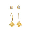 Pair of gold-toned earrings with white topaz studs and lotus flower drop charms on curved hooks.