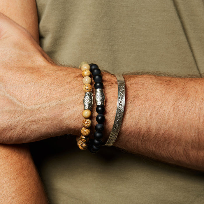 Stylish display of the Men's Blessings and Balance Hamsa Jasper Gemstone Bracelet worn alongside other bracelets, representing spiritual jewelry that embodies protection, meaning, and harmony, ideal for yoga practitioners and those interested in zodiac connections.
