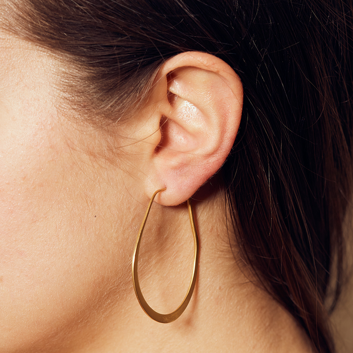 Close-up view of a person wearing Minimalist Gold Hoop Earrings, showcasing their elegant style, fitting for sacred practices and zodiac themes, symbolizing protection and serving as a powerful amulet in daily life.