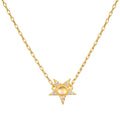 Gold chain necklace with four-pointed star pendant featuring round moonstone center and crystal accents.