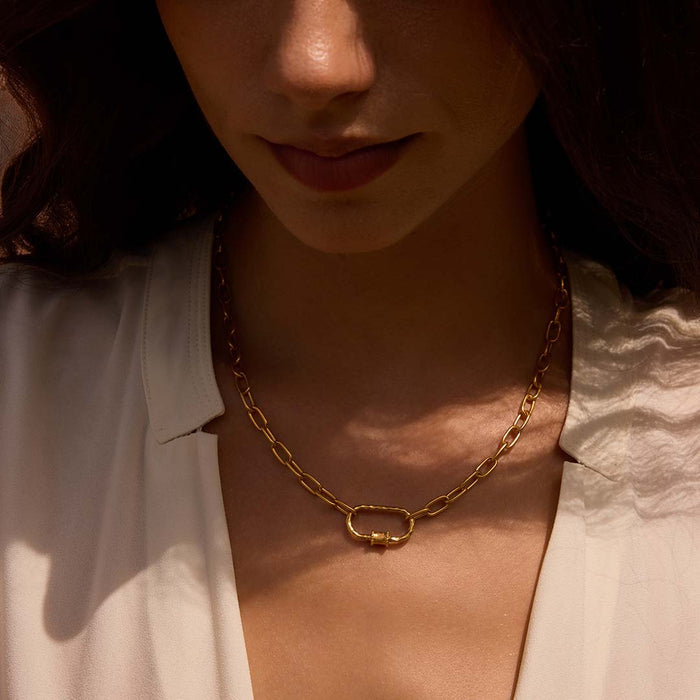 Close-up of a model wearing the New Beginnings Lotus Charm Holder Necklace, highlighting its exquisite design and golden hue. This talisman serves as a beautiful reminder of spiritual growth and connection, ideal for yoga and meditation practices.