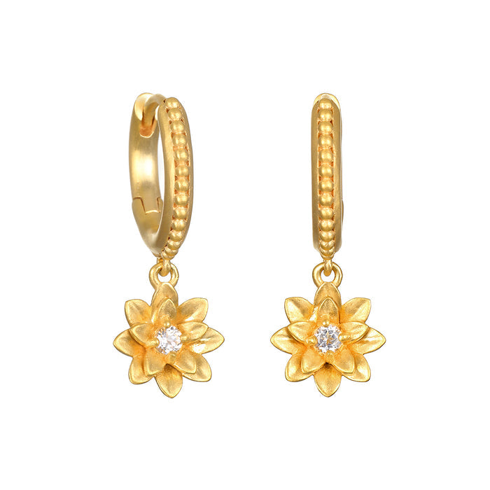 New Chapter Lotus Huggie Earrings featuring a detailed lotus flower design with a sparkling white topaz, embodying spiritual jewelry for meditation and a meaningful talisman for manifestation and protection.