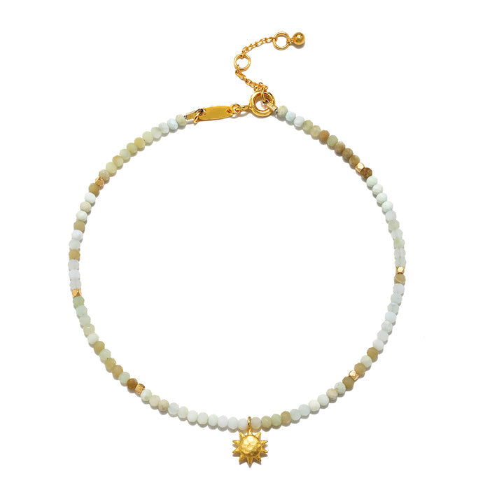 New Dawn Peruvian Opal Anklet featuring a delicate design with shaded green Peruvian opals, symbolizing tranquility and healing, complemented by a gold-plated sun pendant, embodying spiritual jewelry for protection and manifestation during meditation and yoga.