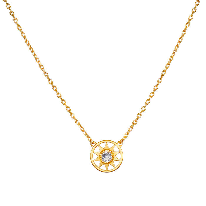 Gold-toned necklace with sun-shaped pendant featuring clear crystal center stone suspended from delicate chain.