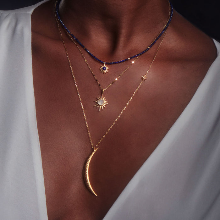 Layered look featuring the North Star Moonstone Starburst Necklace among other spiritual jewelry pieces. Perfect for yoga and meditation enthusiasts, this necklace serves as a meaningful charm for manifestation and connection to the sun and moon.