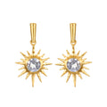 Pair of gold starburst earrings with clear faceted stones in the center and pointed rays radiating outward.