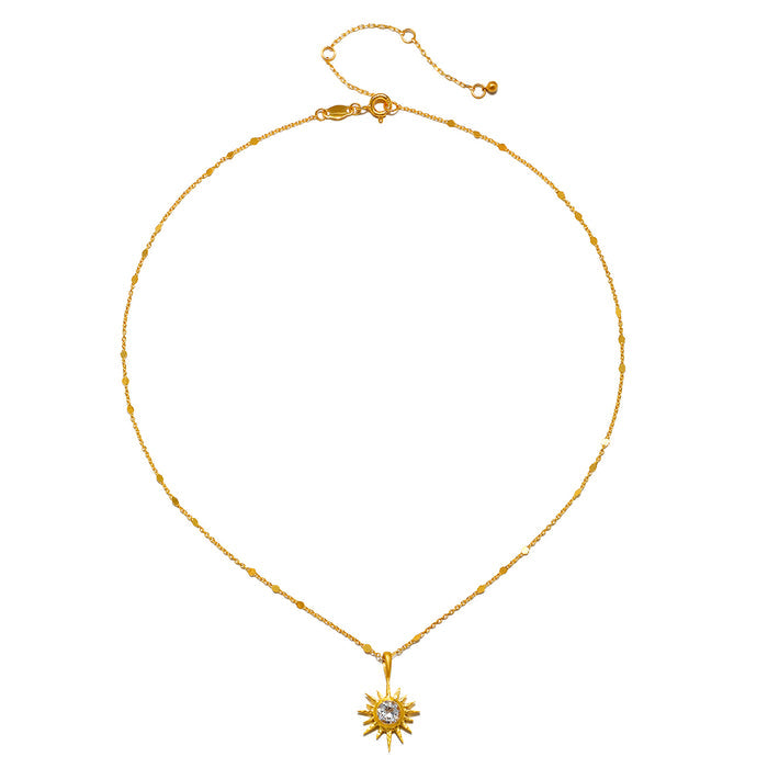 Gold chain necklace with starburst pendant featuring white topaz center stone and lobster clasp.