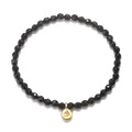 Om Black Onyx Gemstone Bracelet featuring faceted black onyx stones and a gold Om pendant, perfect for spiritual jewelry, meditation gifts, and yoga practices. This meaningful piece is a protective amulet embodying sacred and symbolic significance.