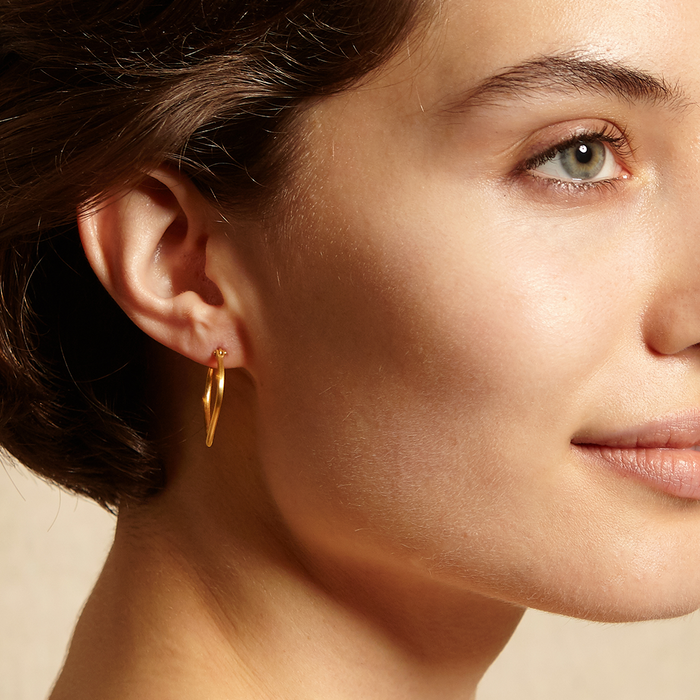 A profile view of a model wearing the Open to Possibilities Earrings. This symbolic accessory reflects the beauty of manifestation and protection, making it an ideal amulet for meditation, yoga, and sacred moments.