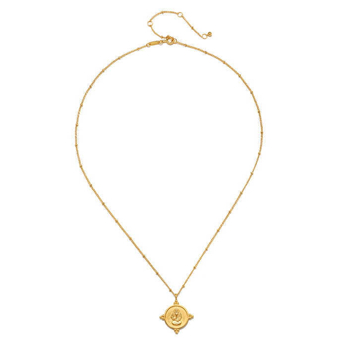 Gold-toned chain necklace with circular Ganesha pendant featuring raised deity imagery and decorative side details.