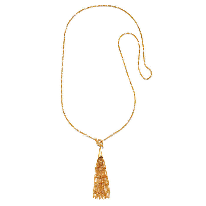 Gold chain necklace with toggle closure and beaded tassel pendant.