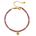 Pink Tourmaline Lotus October Birthstone Bracelet featuring round pink tourmaline beads with an 18kt gold plated lotus flower pendant. This spiritual jewelry piece embodies creativity and inspiration, making it a meaningful talisman for meditation and manifestation. Ideal for yoga enthusiasts and those seeking spiritual protection, this bracelet symbolizes new beginnings and aligns with zodiac energies.