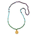 Beaded mala necklace with green, turquoise, blue, and purple stones, gold pendant charm at bottom.