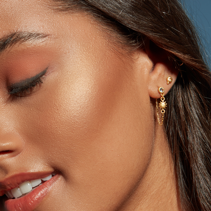 Close-up of a model wearing Promise of Magic Earrings featuring blue topaz and sun and moon pendants, embodying the essence of spiritual jewelry, meditation, and meaningful manifestation.