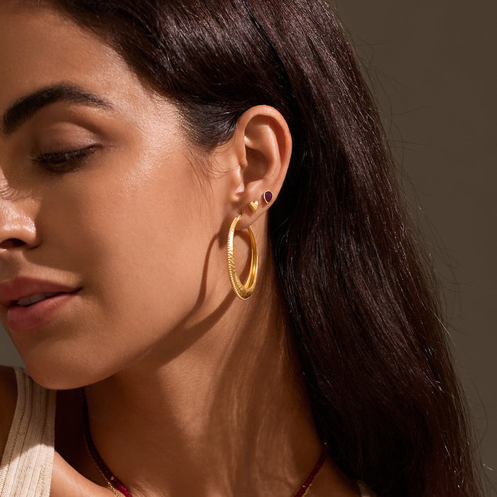 A model wearing Pure Heart Earrings alongside other pieces, highlighting their versatility in an earstack. These earrings serve as a meaningful talisman for protection and spiritual connection, ideal for those embracing zodiac energies and meditation.