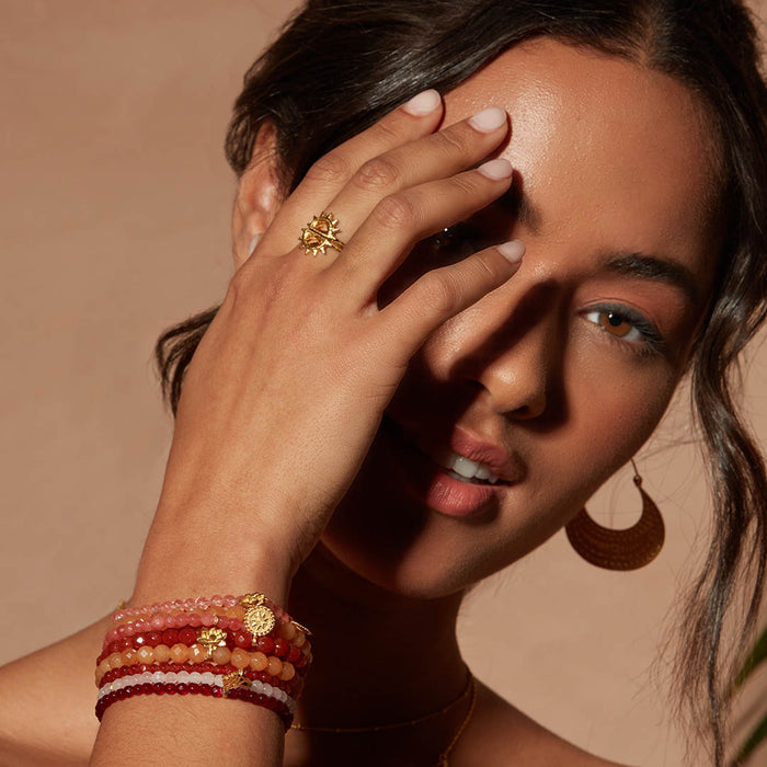 The Reclaim Joy Citrine Sunrise Ring shines on a model's finger, accompanied by bracelets, illustrating its role as a meaningful piece of spiritual jewelry and talisman, representing vitality and warmth.
