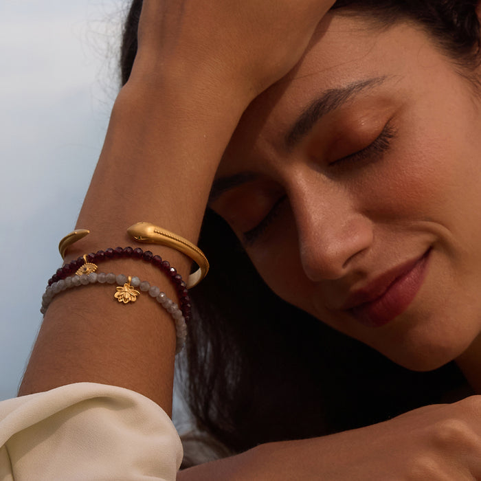 A person wearing the Sacred Guidance Snake Cuff Bracelet, surrounded by complementary spiritual jewelry. The combination of pieces evokes a sense of tranquility and is perfect for those who seek meaning, manifestation, and grounding energies during yoga and meditation.