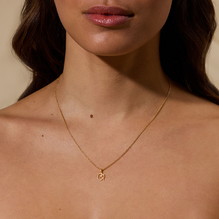 Model wearing the Sacred Om Necklace, showcasing the delicate Om pendant, a representation of spiritual meaning and meditation. This jewelry serves as a beautiful talisman for zodiac lovers, providing protection and enhancing personal energy through manifestation.