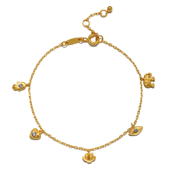 Gold-toned charm bracelet with delicate chain and five symbolic pendants set with white topaz stones.