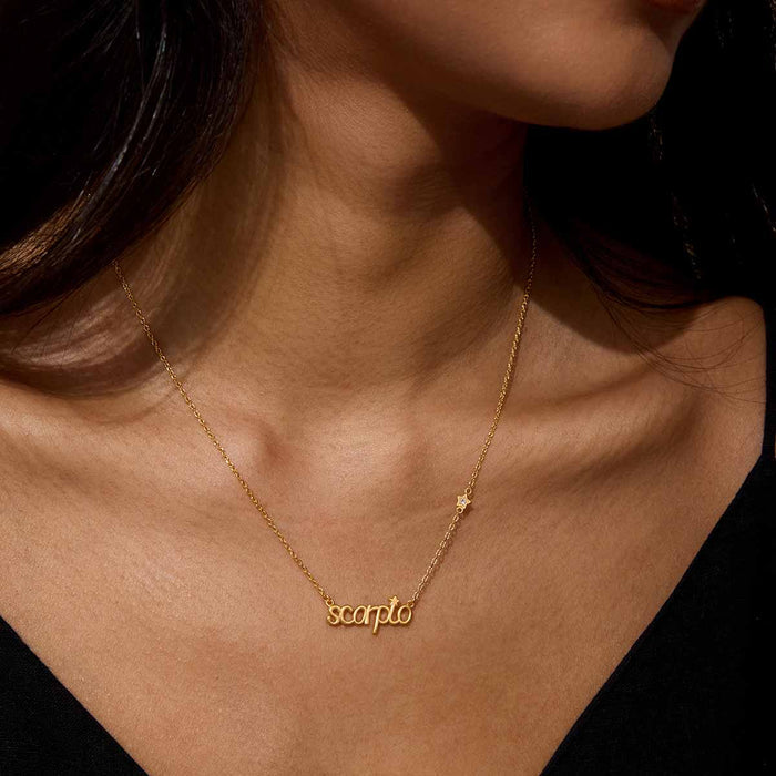 Model wearing the Scorpio Transformation Zodiac Script Necklace with the word 'scorpio' in a stylish gold script, highlighting its role as spiritual jewelry. This piece embodies the essence of meditation and meaningful expression, making it a beautiful talisman for zodiac-inspired manifestation and connection during yoga.