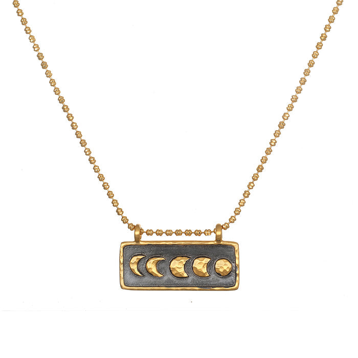 Self Evolution Moon Phase Necklace showcasing the beautiful moon phases on a gold-plated bar against a gunmetal background, perfect for spiritual jewelry and meditation, symbolizing protection and manifestation.