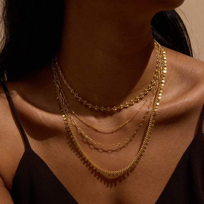 The Shine a Light Coin Chain Necklace layered with other gold necklaces, illustrating a stylish combination of spiritual jewelry and talismans, ideal for manifestation and enhancing your aura.