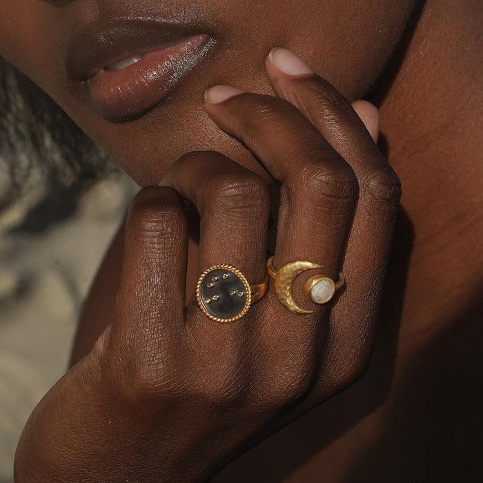 A close-up of a hand wearing the Shine in Sisterhood Constellation Ring alongside other rings, symbolizing the beauty of spiritual jewelry and meaningful connections in yoga and protection.