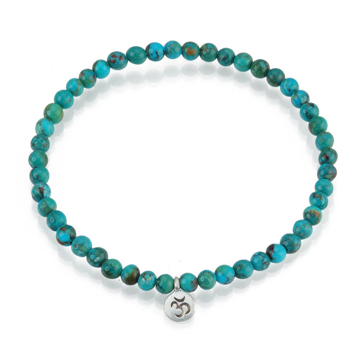 Silver Turquoise Om Stretch Bracelet - Inner Peace, featuring small turquoise stones encircling a sacred Om charm, perfect for adding a meaningful touch to your spiritual jewelry collection. This bracelet represents health and self-expression, making it a wonderful gift for meditation, yoga, and manifestation enthusiasts.