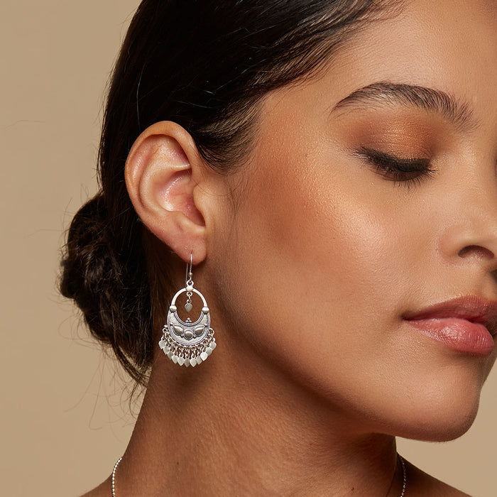 A close-up of a model wearing the Silver Veils - Petal Chandelier Earrings, showcasing their elegant crescent shape and shimmering petals, perfect for those seeking spiritual jewelry and meaningful meditation gifts. These earrings symbolize new beginnings and manifestation, making them a protective amulet for your yoga practice.