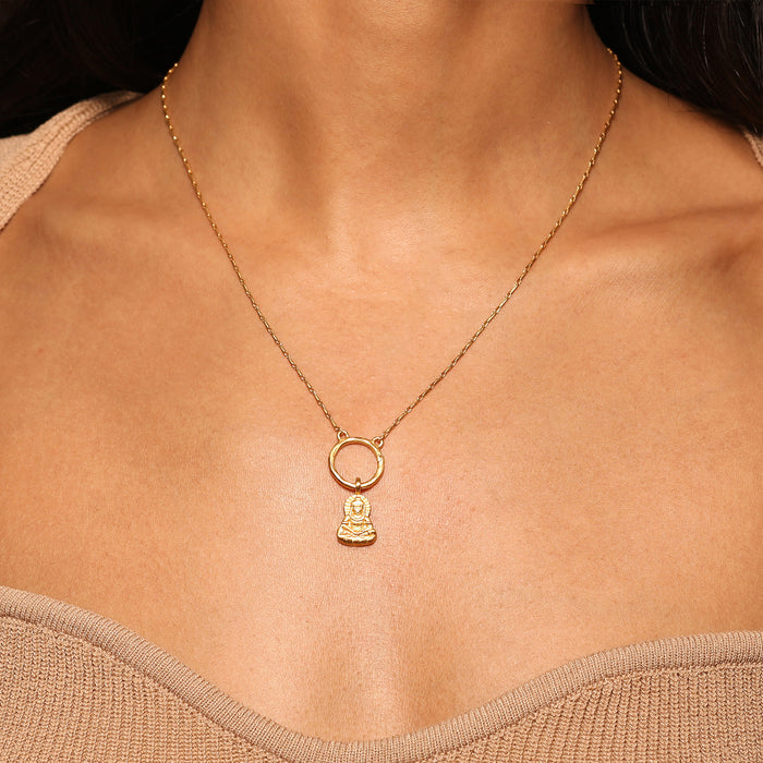 Close-up of a person wearing the Sitting Buddha Charm as a necklace, highlighting its intricate design. This spiritual jewelry piece embodies the essence of meditation and serves as a talisman for meaningful intentions. Great for yoga practitioners seeking protection and tranquility.