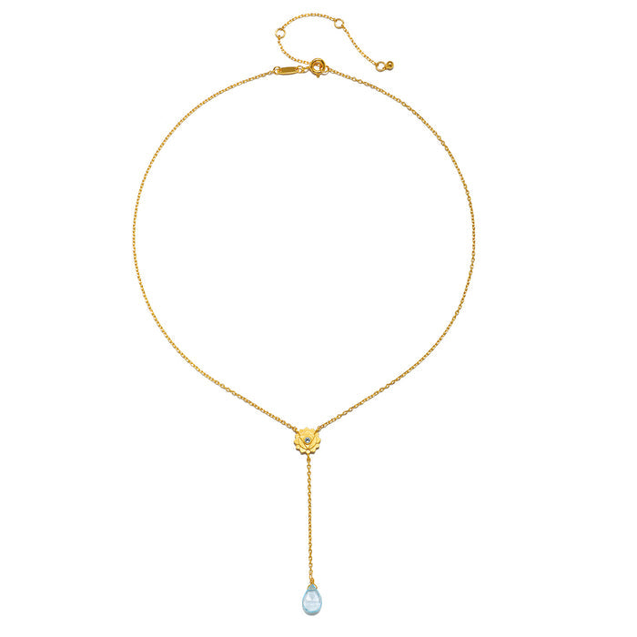 Flat lay of the Speak with Strength Chakra Lariat Necklace displaying its elegant design with blue topaz and gold plating, highlighting its meaning as spiritual jewelry and a meditation talisman for those seeking balance.