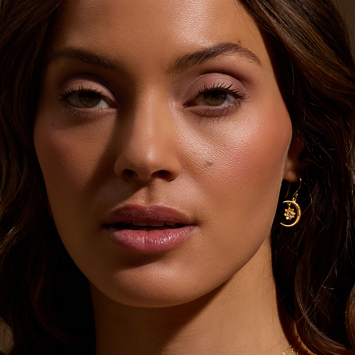 Model elegantly wearing the Spirit in Transformation Lotus Moon Earrings, radiating confidence and grace. This spiritual accessory combines elements of the moon and lotus, making it a charming addition for those interested in meditation, protection, and embracing the deeper meanings of spirituality and yoga.