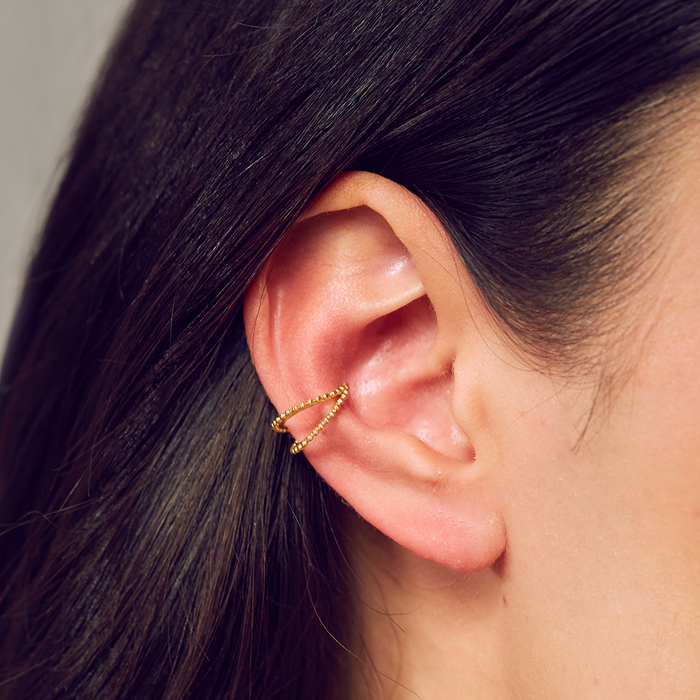 Model highlighting the Stand By Your Side Ear Cuff, emphasizing its unique design in gold plate. This spiritual jewelry piece enhances your aura with meaning while connecting to meditation and zodiac elements.