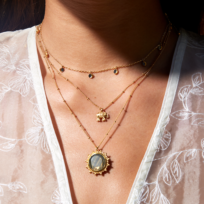 Close-up of the Stand in Strength Elephant Necklace layered with additional gold chains, showcasing its intricate design, perfect as spiritual jewelry for meditation and meaningful mantra practices.