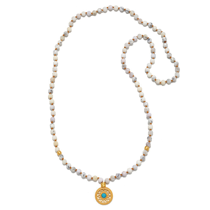 Step Into Self White Opal Mandala Mala featuring 108 white opal beads and an 18kt gold plated mandala pendant with turquoise. This beautiful piece of spiritual jewelry is perfect for meditation and serves as a meaningful talisman for protection and manifestation. Ideal for yoga enthusiasts and those seeking clarity and balance in their spiritual journey.