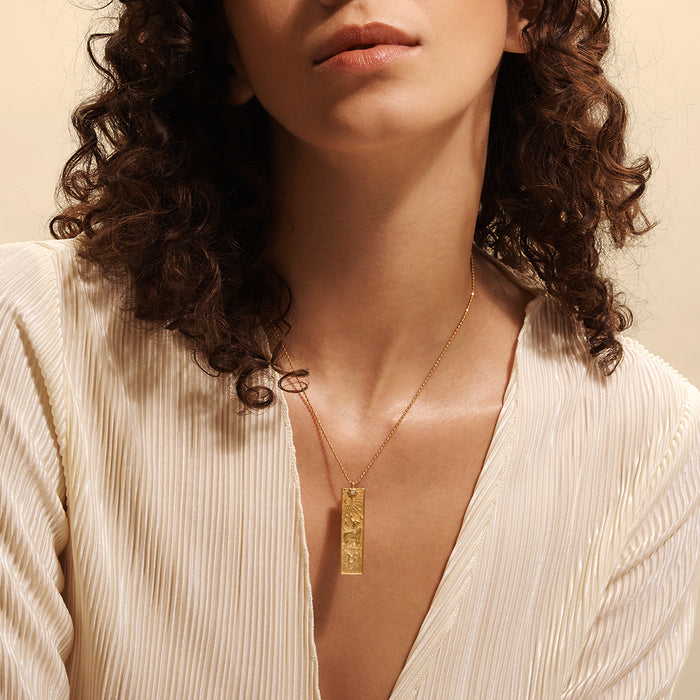 Model wearing the Story of Taurus Zodiac Necklace, showcasing its elegant design on a natural skin tone. This spiritual jewelry serves as a beautiful talisman representing zodiac energies. Its combination of gold, sun, and moon elements provides a sense of protection and enhances meaningful spiritual connections during meditation.