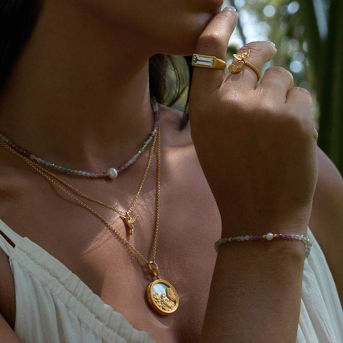 Layered necklaces featuring the Take Flight Butterfly Pearl Locket Necklace, showcasing its intricate design alongside other spiritual jewelry. This collection is ideal for those seeking meaning and balance in yoga and meditation practices.