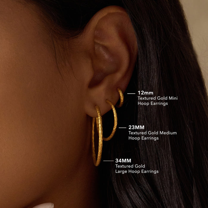 Textured Gold Mini Hoop Earrings alongside medium and large hoop earrings, showcasing their various sizes. These earrings serve as meaningful jewelry pieces that connect with spiritual practices and offer protection through their elegant design.
