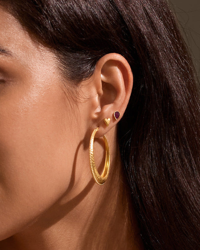 Close-up of Timeless Beauty Dot Hoop Earrings worn by a woman in a chic setting, highlighting their luxurious design. This pair of spiritual jewelry embodies elegance and meaning, making it a great addition to any ear stack. Ideal for those interested in talismans, zodiac influences, and the deep connection to meditation and yoga practice.
