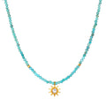 Turquoise bead choker necklace with gold-tone sun pendant featuring a center crystal stone.